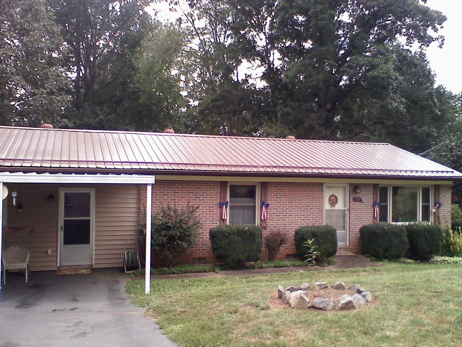 Bronze metal roof and carport on a brick ranch home — Roof Repair work by our crew in Rose Creek